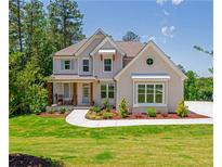 Charming two-story home with a manicured lawn, beautiful landscaping, and a welcoming front porch at 1013 Liberty Springs Dr, Woodstock, GA 30188