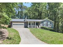 Charming single-story home with a well-maintained lawn and attached two-car garage at 510 Whistlestop Dr, Woodstock, GA 30189