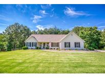 Charming home with well-maintained lawn, manicured bushes, and classic architecture on a sunny day at 1015 Carriage Way, Loganville, GA 30052