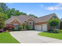 Beautiful brick home featuring manicured landscaping, a spacious driveway, and an attached two-car garage at 4115 Gold Mill Rdg, Canton, GA 30114