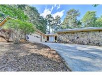 Charming home with stone accents, a long driveway, and an attached two-car garage at 3070 Ascot Ln, Roswell, GA 30076