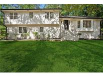 Charming two-story home with a well-manicured lawn and a classic painted brick facade at 4745 Elam Forest Dr, Stone Mountain, GA 30083