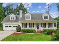 Charming two-story home with a welcoming front porch, two-car garage, and beautiful landscaping at 1624 Glenfield Dr, Lawrenceville, GA 30043