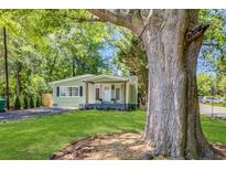 Charming home with a well-maintained front yard and mature trees offering shade and curb appeal at 2572 Bates Se St, Smyrna, GA 30080