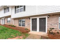 Brick and siding exterior view of townhome with two front doors and well-maintained landscaping at 7 Villa Se Ct, Smyrna, GA 30080
