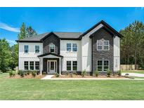 Beautiful two story home featuring stone and white siding under a clear blue sky at 110 Northwood Creek Way, Oxford, GA 30054