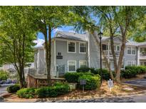 Inviting condo exterior with lush landscaping and a charming, light gray facade and view of the parking area at 1450 Keys Crossing Ne Dr, Brookhaven, GA 30319