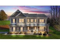 Beautiful two story home with manicured lawn and elegant exterior lighting, featuring a covered front porch at 200 Cherokee Reserve Cir, Canton, GA 30115