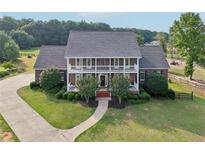 Stately brick home with a charming two-story facade and a meticulously landscaped front yard at 3480 Indian Shoals Rd, Dacula, GA 30019