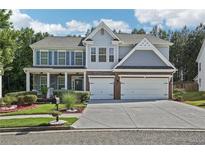 Charming two-story home features a well-manicured lawn, a two-car garage, and an inviting covered front porch at 1017 Preserve Park Dr, Loganville, GA 30052