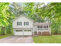 Charming two-story home featuring a welcoming front porch, attached two-car garage, and lush surrounding greenery at 127 Danielle Ct, Villa Rica, GA 30180