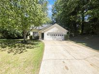 Charming single-story home with a two-car garage and a long driveway nestled among mature shade trees at 1503 Colt Ridge Se Ln, Mableton, GA 30126