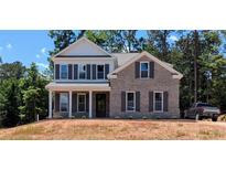 Charming two-story brick home featuring classic architectural details, dark shutters, and a well-manicured front yard at 8239 High Lake Ter, Covington, GA 30014