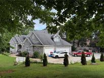 Charming stone home featuring a spacious three-car garage and a lush front lawn at 3393 Childers Ne Rd, Roswell, GA 30075