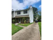 Traditional two-story townhome with vinyl siding, stone accents, and a paved driveway under a partly cloudy sky at 3503 Ten Oaks Court Ct, Powder Springs, GA 30127