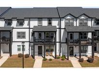 Modern townhouse with black and white trim, front porch, and well-manicured lawn at 823 Mackay Crk, Woodstock, GA 30188