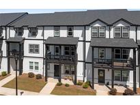 Charming townhome exterior showcases a modern black-and-white design with inviting front porches and landscaped yard at 823 Mackay Crk, Woodstock, GA 30188