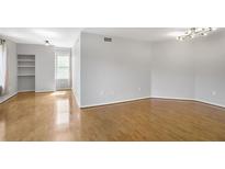 Spacious living room with hardwood floors, modern lighting, and built in shelving at 199 14Th Ne St # 402, Atlanta, GA 30309