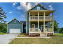 Charming two-story home features a double porch, blue siding, and an attached garage at 1993 Reynolds Sw Dr, Atlanta, GA 30315