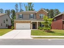 Charming two-story home featuring a brick and gray facade, manicured lawn, and a two-car garage at 510 Cunninghame Ct, Peachtree City, GA 30269