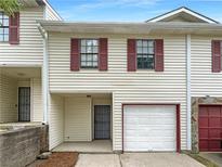 Charming townhome featuring an attached garage and red window shutters at 3008 Pine Tree Trl # 16D, Atlanta, GA 30349