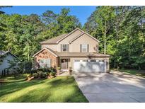 Charming two-story home with a brick and siding facade, landscaped lawn, and a two-car garage at 1156 Magnolia Dr, Villa Rica, GA 30180