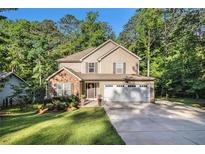 Charming two-story home with a well-manicured lawn and a two-car garage in a lush, wooded setting at 1156 Magnolia Dr, Villa Rica, GA 30180