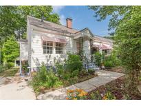 Charming bungalow home with white siding, pink awnings, mature landscaping and inviting front porch at 2669 Jefferson Terrace Ter, East Point, GA 30344
