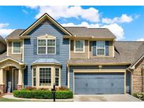 Beautiful two-story home featuring blue siding, a two-car garage, and manicured landscaping at 2685 Sardis Chase Ct, Buford, GA 30519