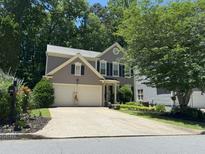 Charming two-story home with a two-car garage, well-manicured lawn, and mature trees at 10000 Barston Ct, Johns Creek, GA 30022