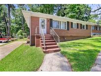 Charming brick ranch-style home featuring a well-maintained lawn and mature trees at 2215 Springdale Sw Rd, Atlanta, GA 30315