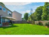 Expansive backyard featuring lush green grass, a patio with seating, and mature trees, perfect for outdoor entertaining at 3692 Ramsey Cir, Atlanta, GA 30331