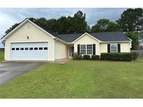 Charming single-story home with manicured lawn, attached garage, and welcoming curb appeal at 929 Wexford Way, Auburn, GA 30011
