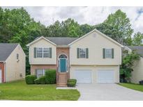 Charming two-story home featuring a well-manicured lawn and a two-car garage at 5937 Yellowood Ct, Atlanta, GA 30349
