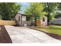Charming single-story home featuring a stone facade, new driveway and a well-manicured front yard at 1130 Mclinden Se Ave, Smyrna, GA 30080