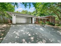 Brick home with a two-car carport on a tree-filled lot at 1425 Dalewood Ne Dr, Atlanta, GA 30329