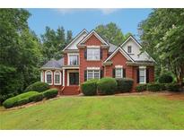 Charming brick home with manicured lawn and mature trees in a well-kept neighborhood at 315 Glengarry Chase, Covington, GA 30014