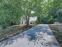 Spacious front yard with mature tree, long driveway and partial view of home at 4601 Ethel Springs Sw Trl, Mableton, GA 30126