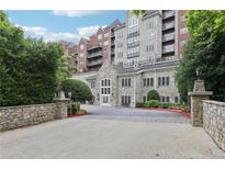 Elegant condo building featuring a stone facade, landscaped entrance, and secure access at 3280 Stillhouse Se Ln # 212, Atlanta, GA 30339