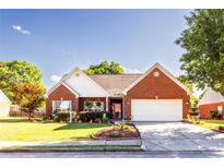 Charming single-story brick home with a well-manicured lawn and attached two-car garage at 381 Crossroads Dr, Social Circle, GA 30025
