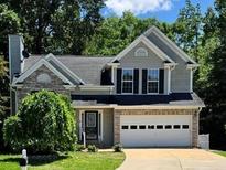 Two-story home featuring a brick and vinyl exterior, attached two-car garage, and mature landscaping at 4000 Mcpherson Drive, Acworth, GA 30101