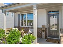 Inviting covered front porch with seating area and stylish front door at 150 Ivy Chase Loop, Dallas, GA 30157