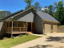 Beautiful home with gray siding, brick accents, 2-car garage, and inviting front porch at 5950 Lynfield Dr, Atlanta, GA 30349