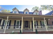 Inviting home featuring a large front porch with detailed columns and charming dormer windows at 3765 Cannonwolde Dr, Snellville, GA 30039