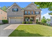 Charming two-story brick home with a well-manicured lawn and inviting front porch at 4022 Roberts Crest Dr, Suwanee, GA 30024