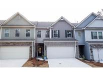 Attractive townhome featuring a well-manicured lawn, a two car garage, and stone accents at 2304 Shetley Creek Dr, Norcross, GA 30071