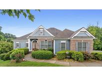 Charming one story home with manicured landscaping, and a brick and light blue facade at 300 Towne Overlook Cir, Canton, GA 30114