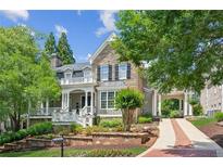 Charming stone and siding home with a covered front porch, porte-cochere, and beautifully landscaped front yard at 3903 Hazelhurst Dr, Marietta, GA 30066