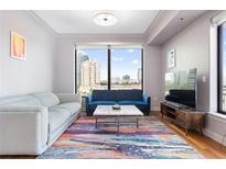 Bright living room featuring large windows with city views, hardwood floors, and contemporary furnishings at 3445 Stratford Ne Rd # 903, Atlanta, GA 30326
