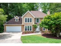 Charming two-story home featuring a well-manicured lawn, two-car garage, and a welcoming stone-accented entrance at 313 Clubhouse Nw Ct, Kennesaw, GA 30144